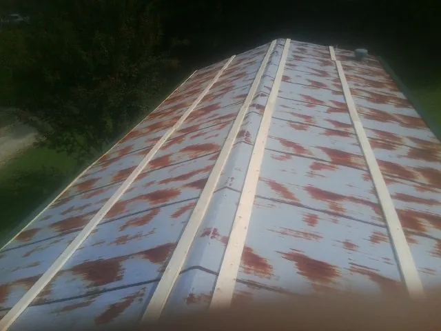 Rusted metal roof panels with new wood purlins before replacement — Storm Damage Roof Repair in Canute by Roofing Brothers