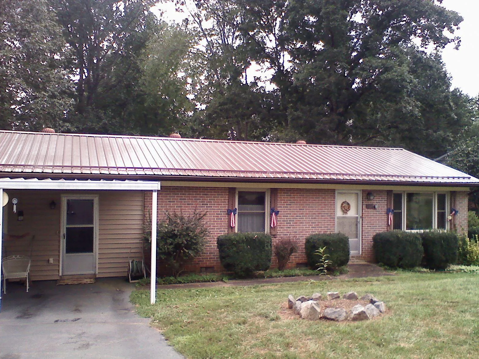 Bronze metal roof and carport on a brick ranch home — Roof Repair work by our crew in Canute
