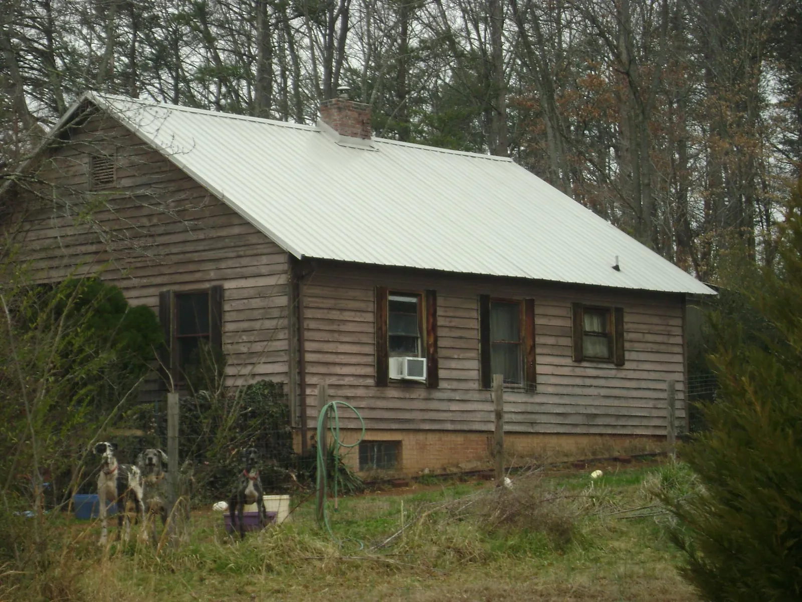 White metal roof on an old wood sided farmhouse, from a Metal Roof Installation job in Canute